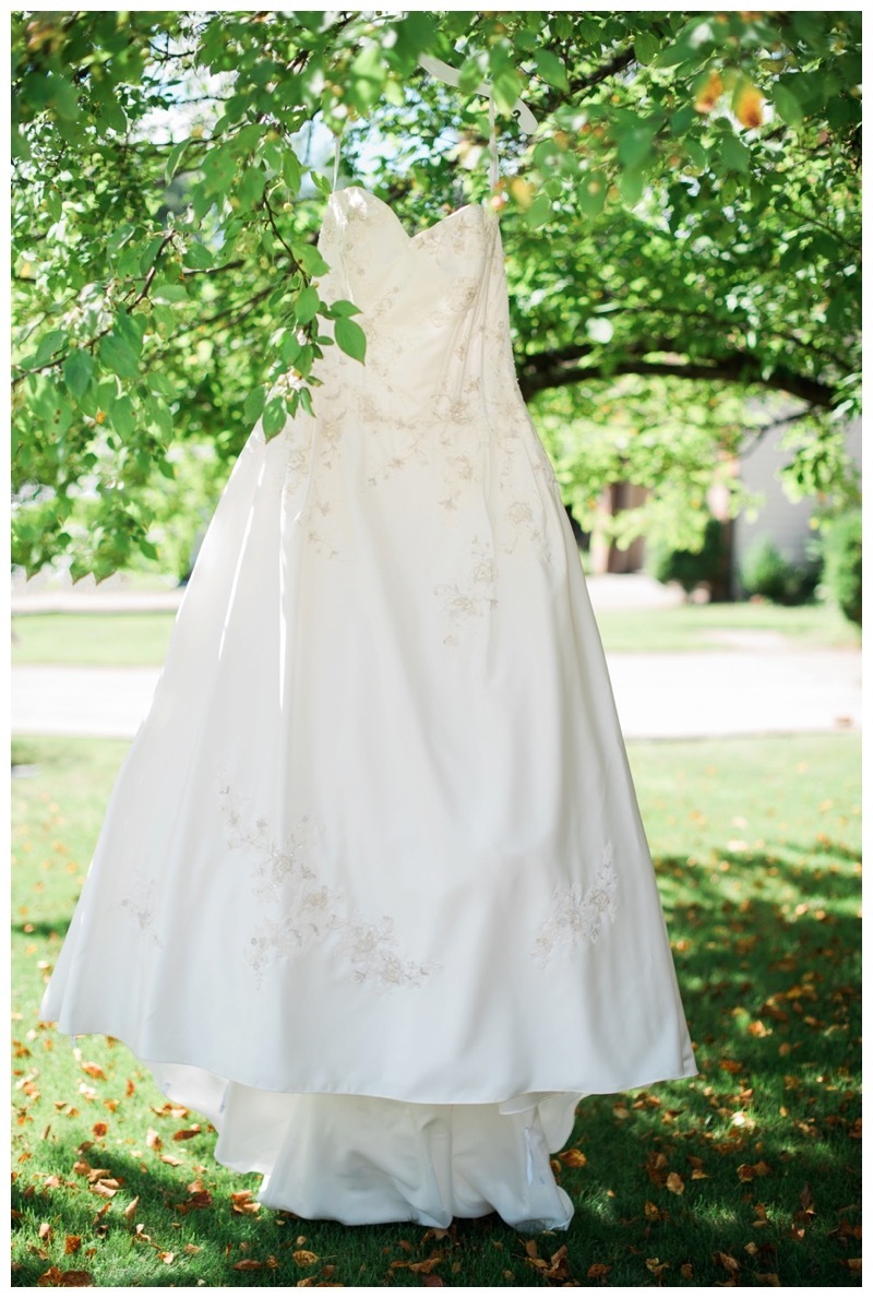 A brides dress hangs in front of her mother's house.
